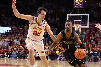 Jan 20, 2026; Ames, Iowa, USA; UCF Knights guard Themus Fulks (1) is defended by Iowa State Cyclones forward Milan Momcilovic (22) during the first half at James H. Hilton Coliseum. Mandatory Credit: Reese Strickland-Imagn Images