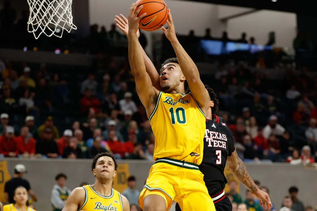 Jan 20, 2026; Waco, Texas, USA; Baylor Bears guard Isaac Williams (10) drives to the basket ahead of Texas Tech Red Raiders forward Lejuan Watts (3) during the second half at Paul and Alejandra Foster Pavilion. Mandatory Credit: Chris Jones-Imagn Images