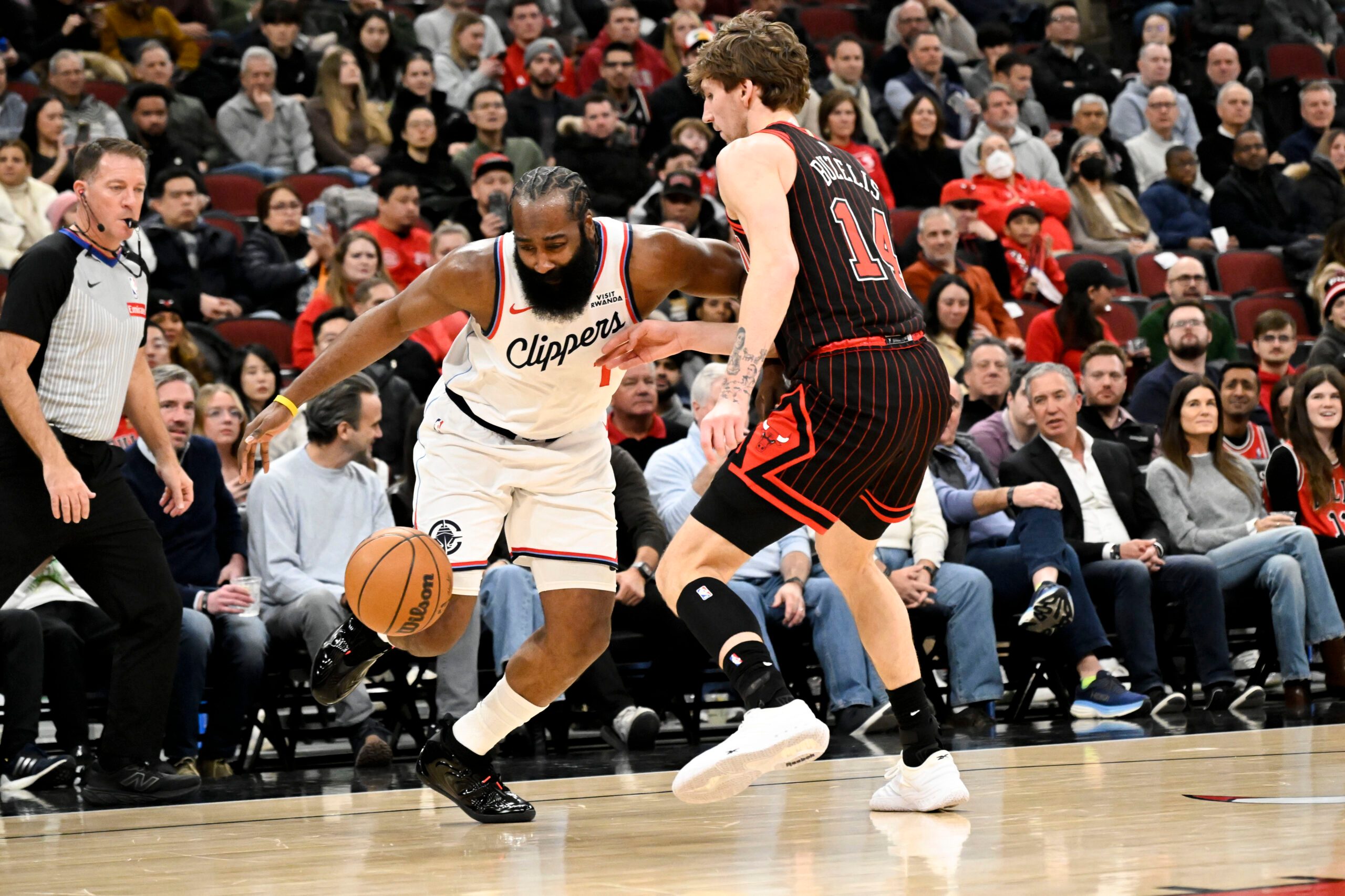 Jan 20, 2026; Chicago, Illinois, USA; LA Clippers guard James Harden (1) drives against Chicago Bulls forward Matas Buzelis (14) during the first half at United Center. Mandatory Credit: Matt Marton-Imagn Images