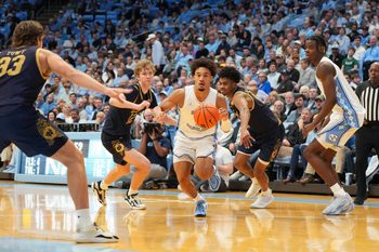 Jan 21, 2026; Chapel Hill, North Carolina, USA; North Carolina Tar Heels guard Seth Trimble (7) dribbles as Notre Dame Fighting Irish forward Carson Towt (33) and forward Garrett Sundra (12) and forward Jalen Haralson (10) defend in the second half at Dean E. Smith Center. Mandatory Credit: Bob Donnan-Imagn Images
