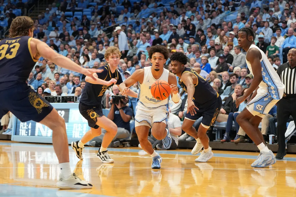Jan 21, 2026; Chapel Hill, North Carolina, USA; North Carolina Tar Heels guard Seth Trimble (7) dribbles as Notre Dame Fighting Irish forward Carson Towt (33) and forward Garrett Sundra (12) and forward Jalen Haralson (10) defend in the second half at Dean E. Smith Center. Mandatory Credit: Bob Donnan-Imagn Images