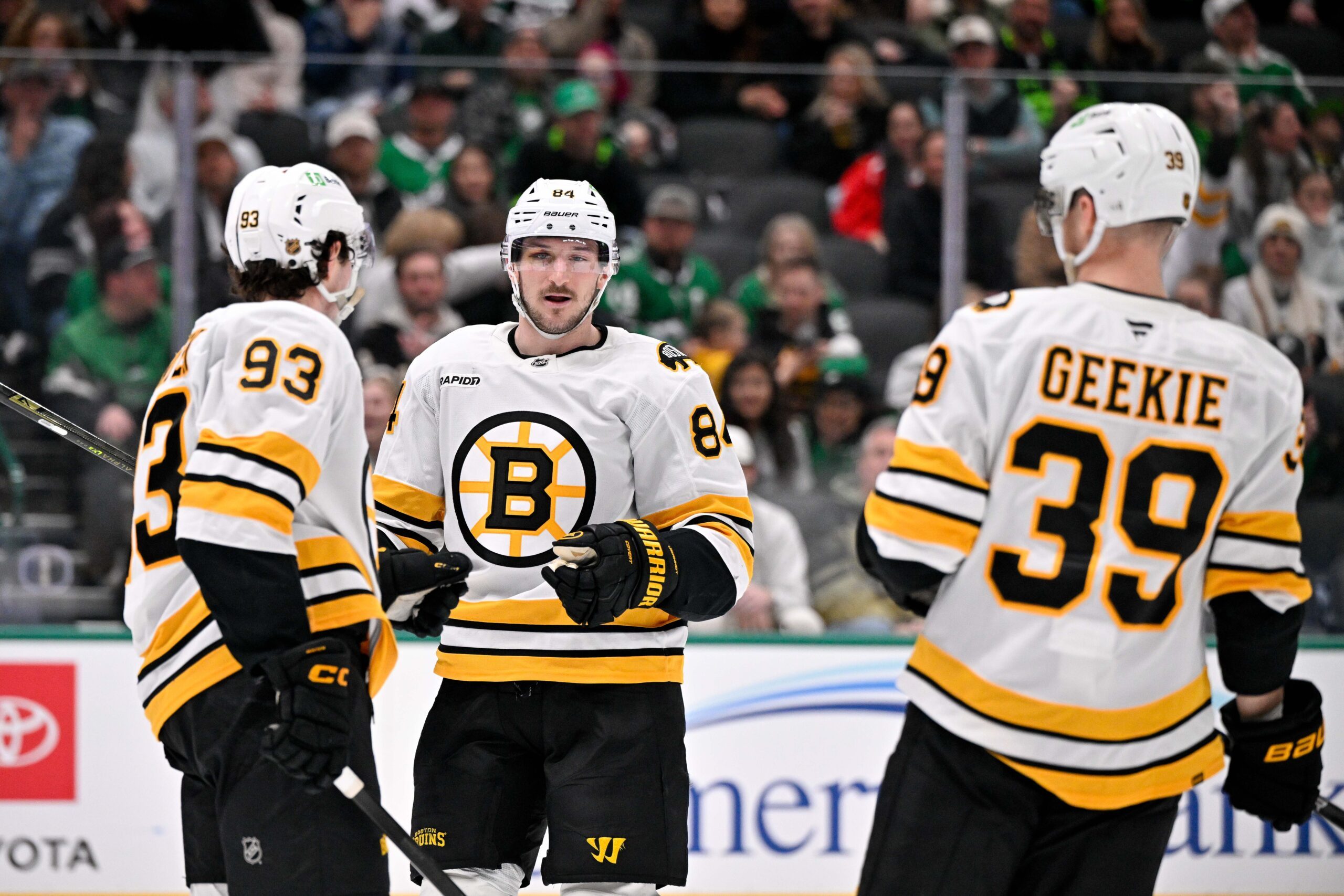 Jan 20, 2026; Dallas, Texas, USA;  Boston Bruins center Fraser Minten (93) and left wing Tanner Jeannot (84) and center Morgan Geekie (39) celebrates a goal scored against the Dallas Stars during the game at the American Airlines Center. Mandatory Credit: Jerome Miron-Imagn Images