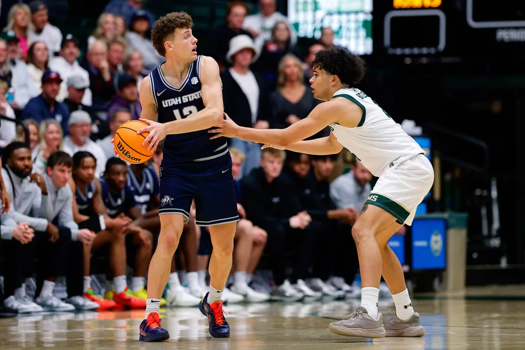 Jan 23, 2026; Fort Collins, Colorado, USA; Utah State Aggies guard Mason Falslev (12) controls the ball as Colorado State Rams guard Jase Butler (4) guards in the second half at Moby Arena. Mandatory Credit: Isaiah J. Downing-Imagn Images