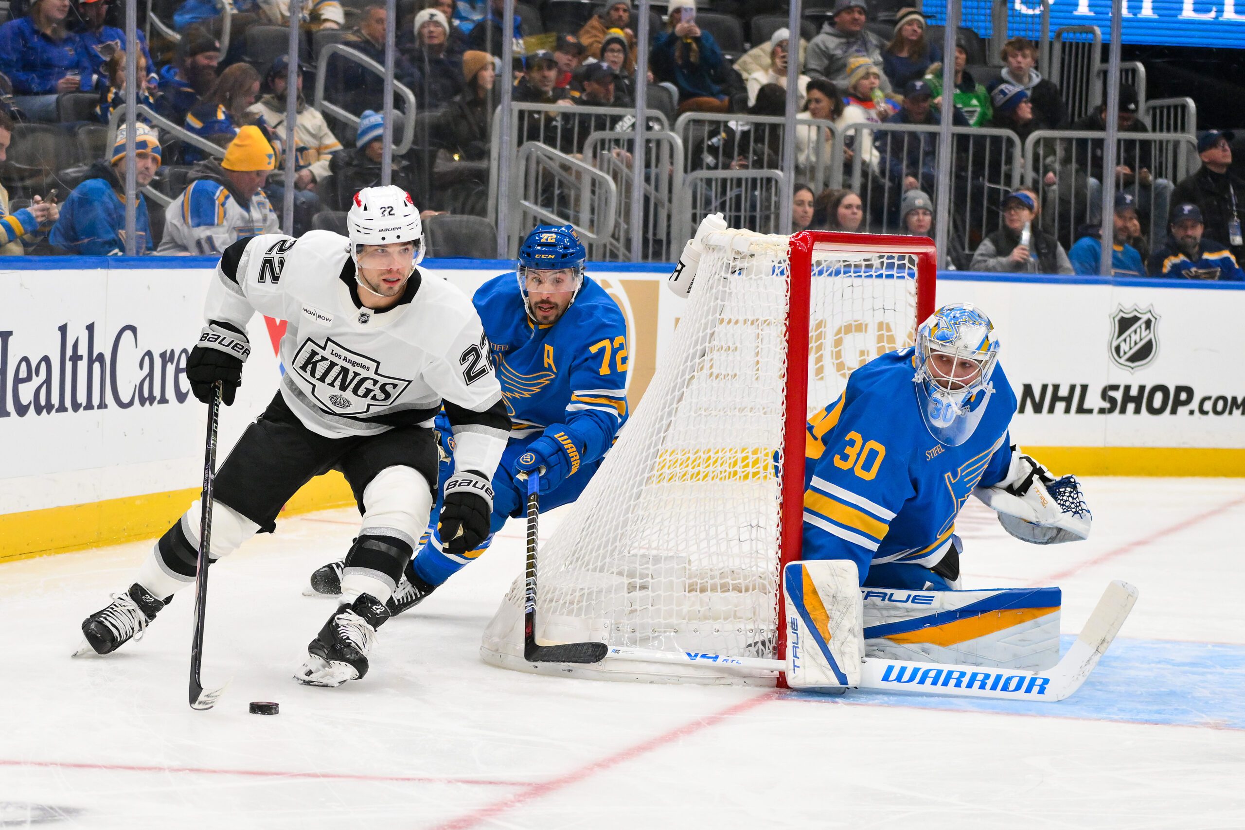 Jan 24, 2026; St. Louis, Missouri, USA; Los Angeles Kings left wing Kevin Fiala (22) controls the puck as St. Louis Blues defenseman Justin Faulk (72) and goaltender Joel Hofer (30) defend the net during the first period at Enterprise Center. Mandatory Credit: Jeff Curry-Imagn Images
