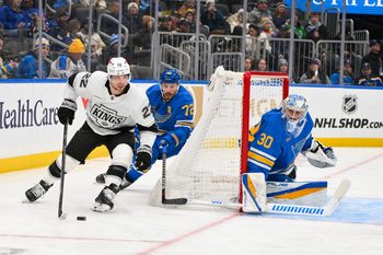 Jan 24, 2026; St. Louis, Missouri, USA; Los Angeles Kings left wing Kevin Fiala (22) controls the puck as St. Louis Blues defenseman Justin Faulk (72) and goaltender Joel Hofer (30) defend the net during the first period at Enterprise Center. Mandatory Credit: Jeff Curry-Imagn Images