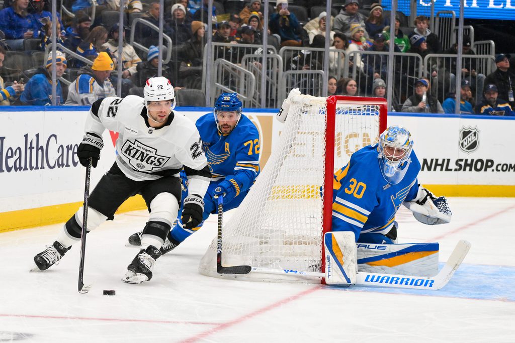Jan 24, 2026; St. Louis, Missouri, USA; Los Angeles Kings left wing Kevin Fiala (22) controls the puck as St. Louis Blues defenseman Justin Faulk (72) and goaltender Joel Hofer (30) defend the net during the first period at Enterprise Center. Mandatory Credit: Jeff Curry-Imagn Images
