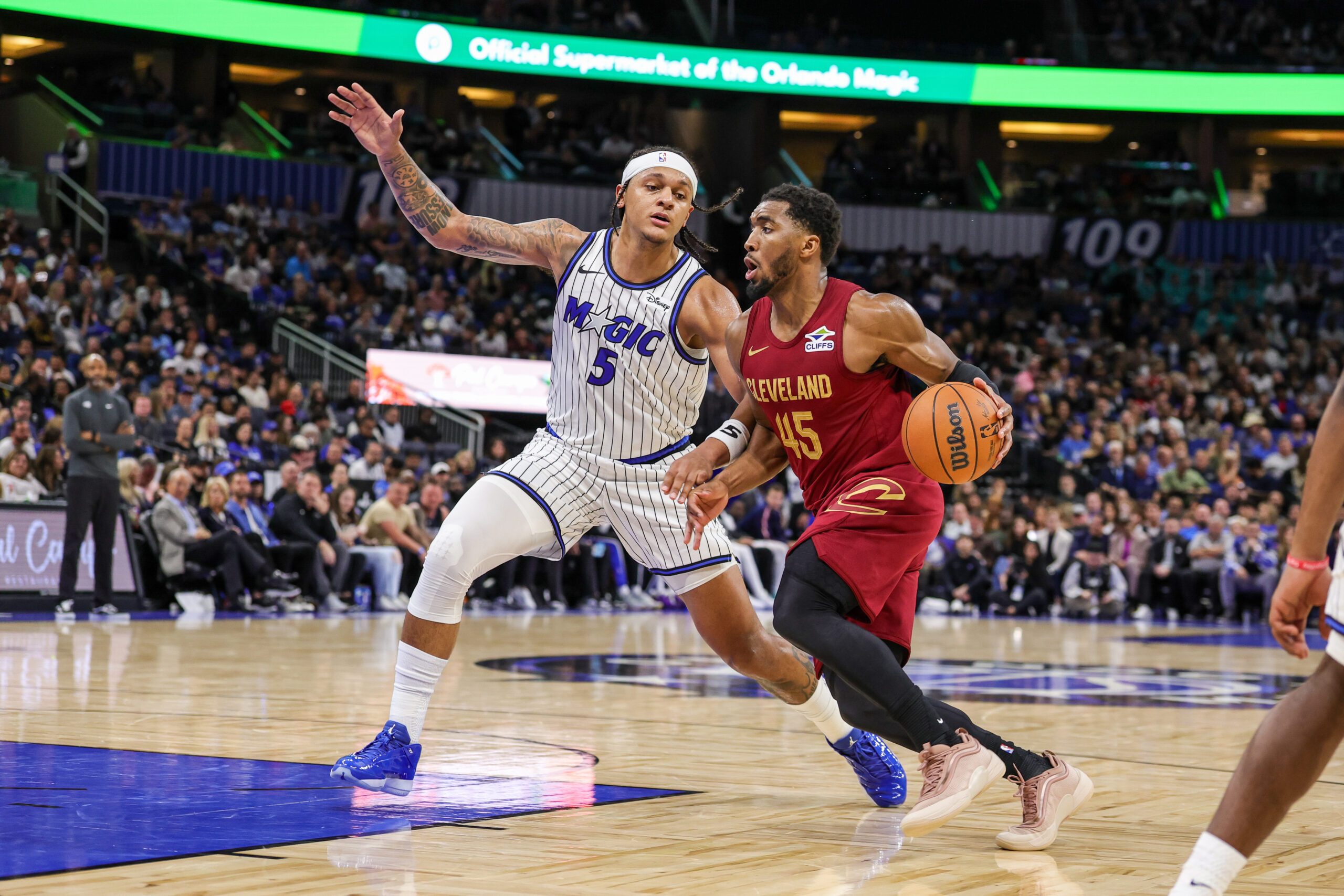 Jan 24, 2026; Orlando, Florida, USA; Cleveland Cavaliers guard Donovan Mitchell (45) drives around Orlando Magic forward Paolo Banchero (5) during the second half at Kia Center. Mandatory Credit: Mike Watters-Imagn Images