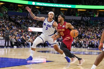 Jan 24, 2026; Orlando, Florida, USA; Cleveland Cavaliers guard Donovan Mitchell (45) drives around Orlando Magic forward Paolo Banchero (5) during the second half at Kia Center. Mandatory Credit: Mike Watters-Imagn Images