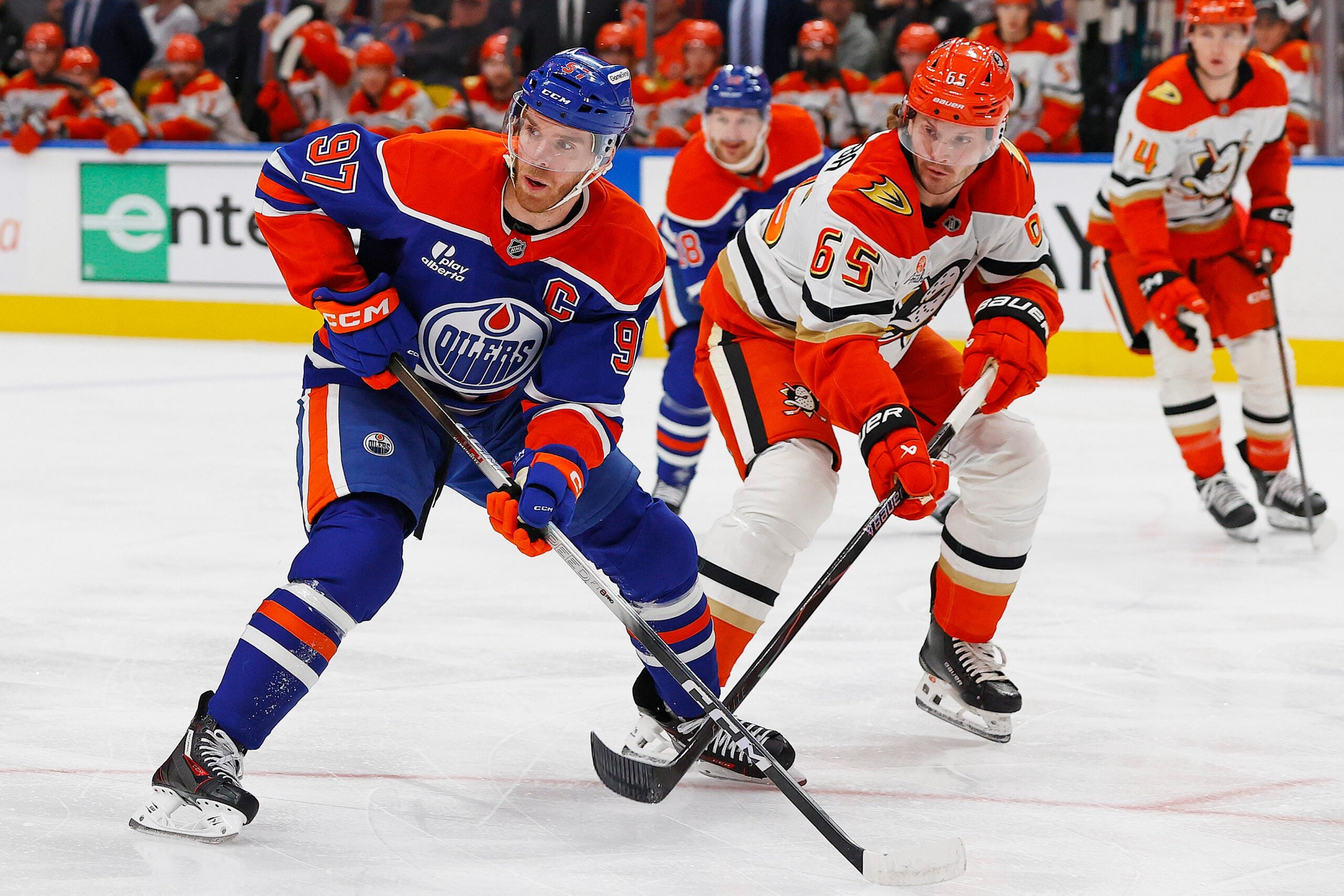 Jan 26, 2026; Edmonton, Alberta, CAN; Edmonton Oilers forward Connor McDavid (97) and Anaheim Ducks defensemen Jacob Trouba (65) look for a loose puck during the first period at Rogers Place. Mandatory Credit: Perry Nelson-Imagn Images