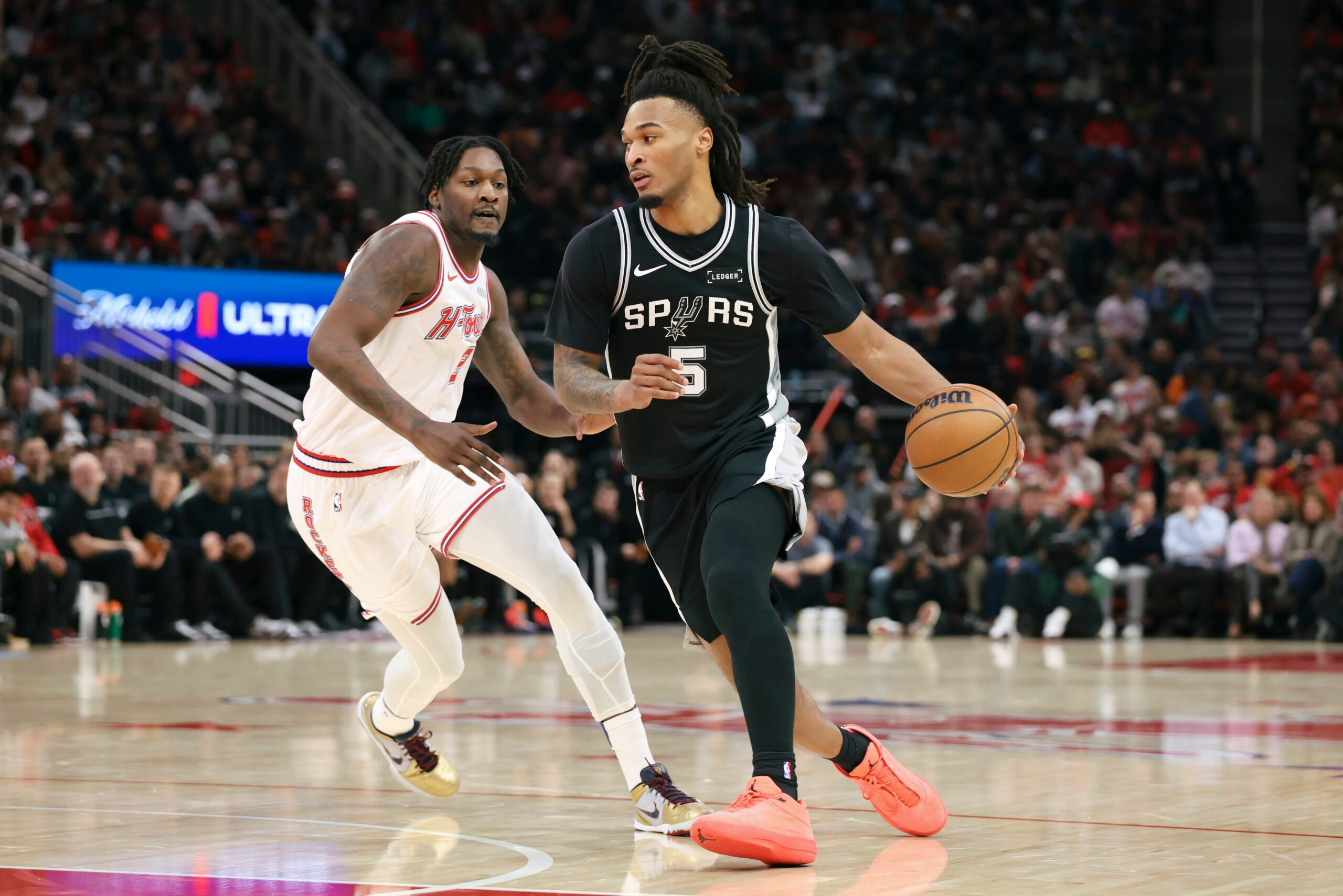Jan 28, 2026; Houston, Texas, USA; San Antonio Spurs guard Stephon Castle (5) dribbles the ball as Houston Rockets forward Dorian Finney-Smith (2) defends during the third quarter at Toyota Center. Mandatory Credit: Troy Taormina-Imagn Images