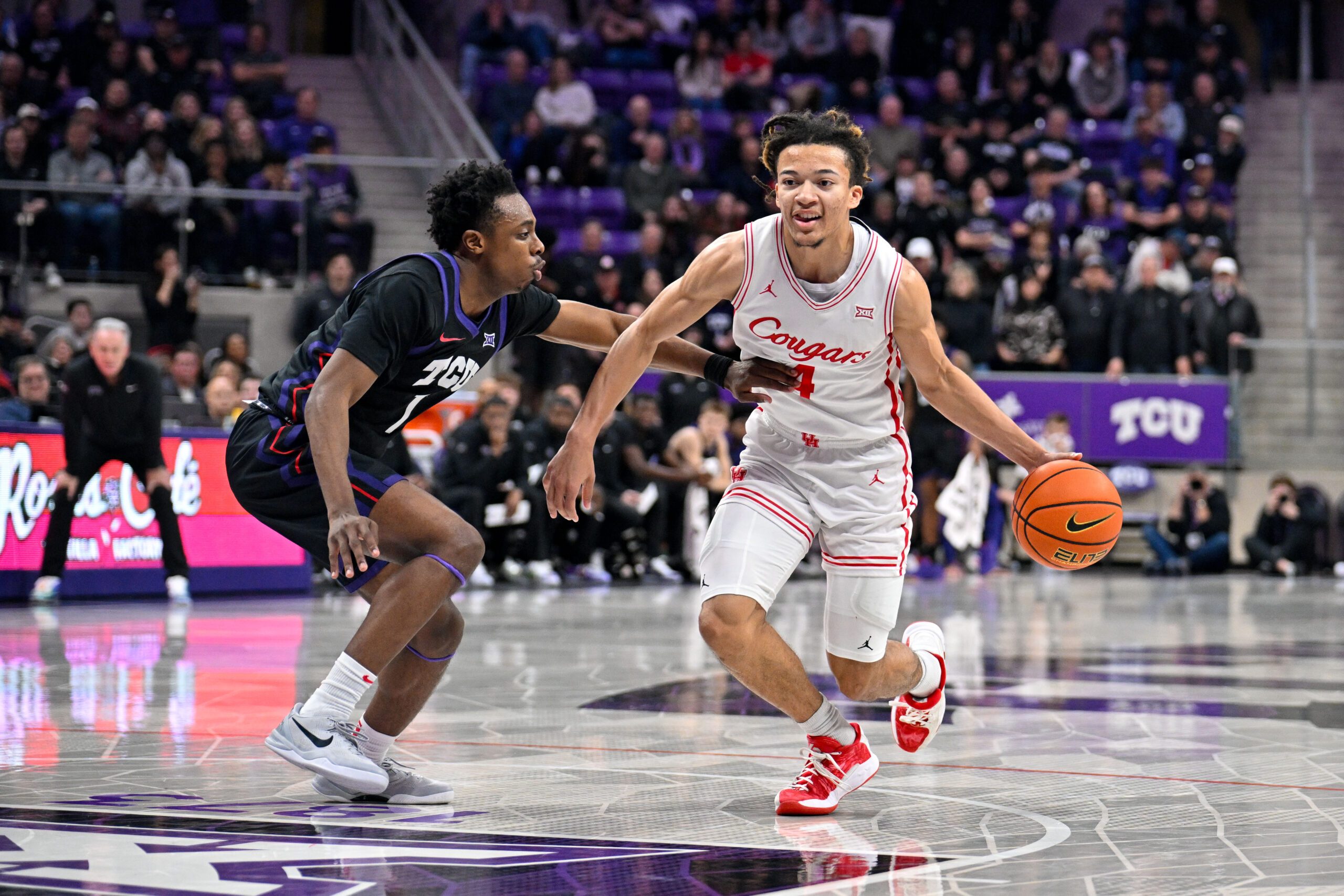 Jan 28, 2026; Fort Worth, Texas, USA; Houston Cougars guard Kingston Flemings (4) brings the ball up court past TCU Horned Frogs guard Jayden Pierre (1) during the game at Ed and Rae Schollmaier Arena. Mandatory Credit: Jerome Miron-Imagn Images