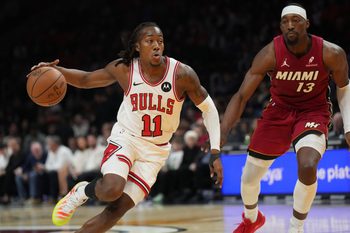 Jan 31, 2026; Miami, Florida, USA;  Chicago Bulls guard Ayo Dosunmu (11) drives to the basket as Miami Heat center Bam Adebayo (13) defends during the first half at Kaseya Center. Mandatory Credit: Jim Rassol-Imagn Images