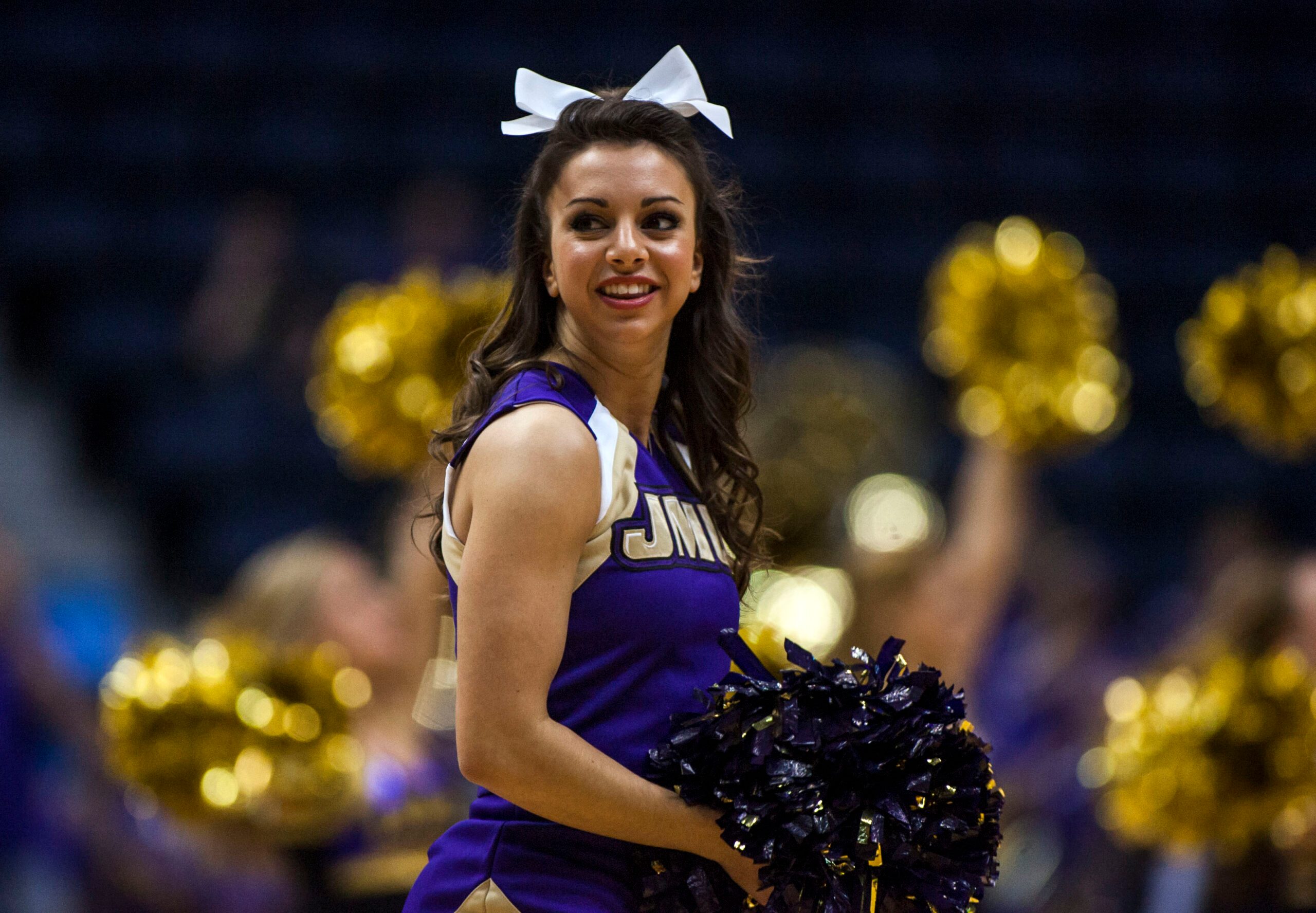 Mar 9, 2013; Richmond, VA, USA; A James Madison Dukes cheerleader preforms during a timeout against the William & Mary Tribe in the quarterfinals of the CAA Tournament at the Richmond Coliseum. Mandatory Credit: Peter Casey-Imagn Images