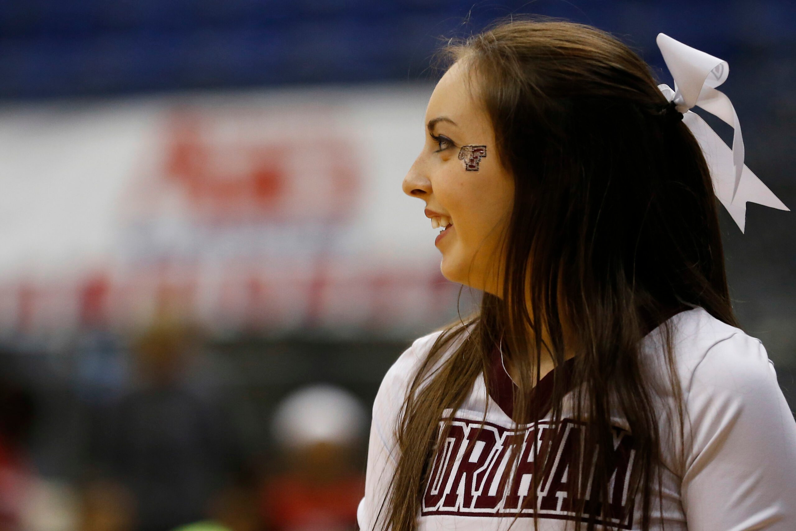 Mar 9, 2014; Richmond, VA, USA; A Fordham Lady Rams cheerleader smiles on the court against the Dayton Flyers in the first half in the Atlantic 10 Conference Tournament Championship at Richmond Coliseum. The Rams won 63-51. Mandatory Credit: Geoff Burke-Imagn Images