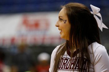 Mar 9, 2014; Richmond, VA, USA; A Fordham Lady Rams cheerleader smiles on the court against the Dayton Flyers in the first half in the Atlantic 10 Conference Tournament Championship at Richmond Coliseum. The Rams won 63-51. Mandatory Credit: Geoff Burke-Imagn Images