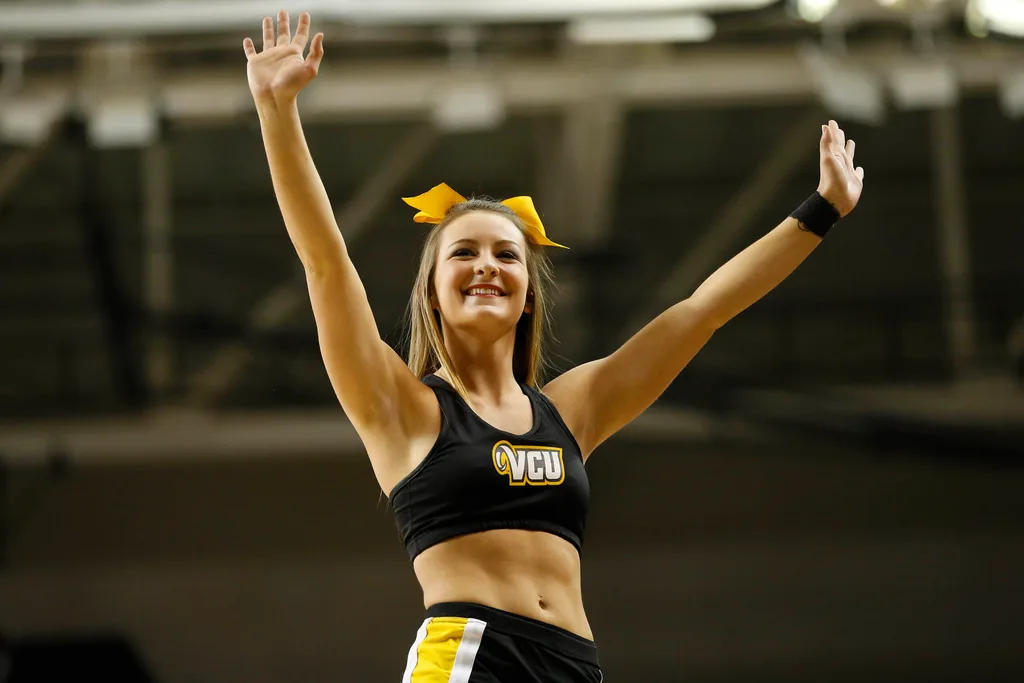 Mar 7, 2015; Richmond, VA, USA; A Virginia Commonwealth Rams cheerleader waves to the crowd during a stoppage in play against the George Mason Patriots in the first half at Stuart Siegel Center. The Rams won 71-60. Mandatory Credit: Geoff Burke-Imagn Images