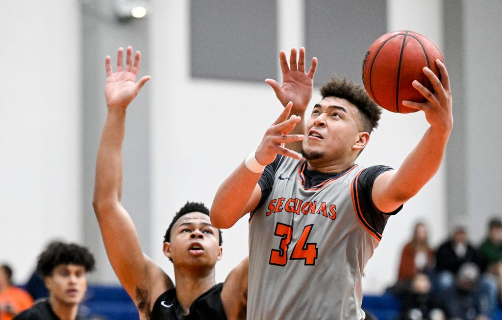 College of the Sequoias' Terri Miller shoots under pressure from Reedley's Justin Parks in men's basketball on Wednesday, February 9, 2022.