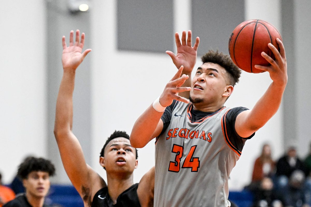 College of the Sequoias' Terri Miller shoots under pressure from Reedley's Justin Parks in men's basketball on Wednesday, February 9, 2022.