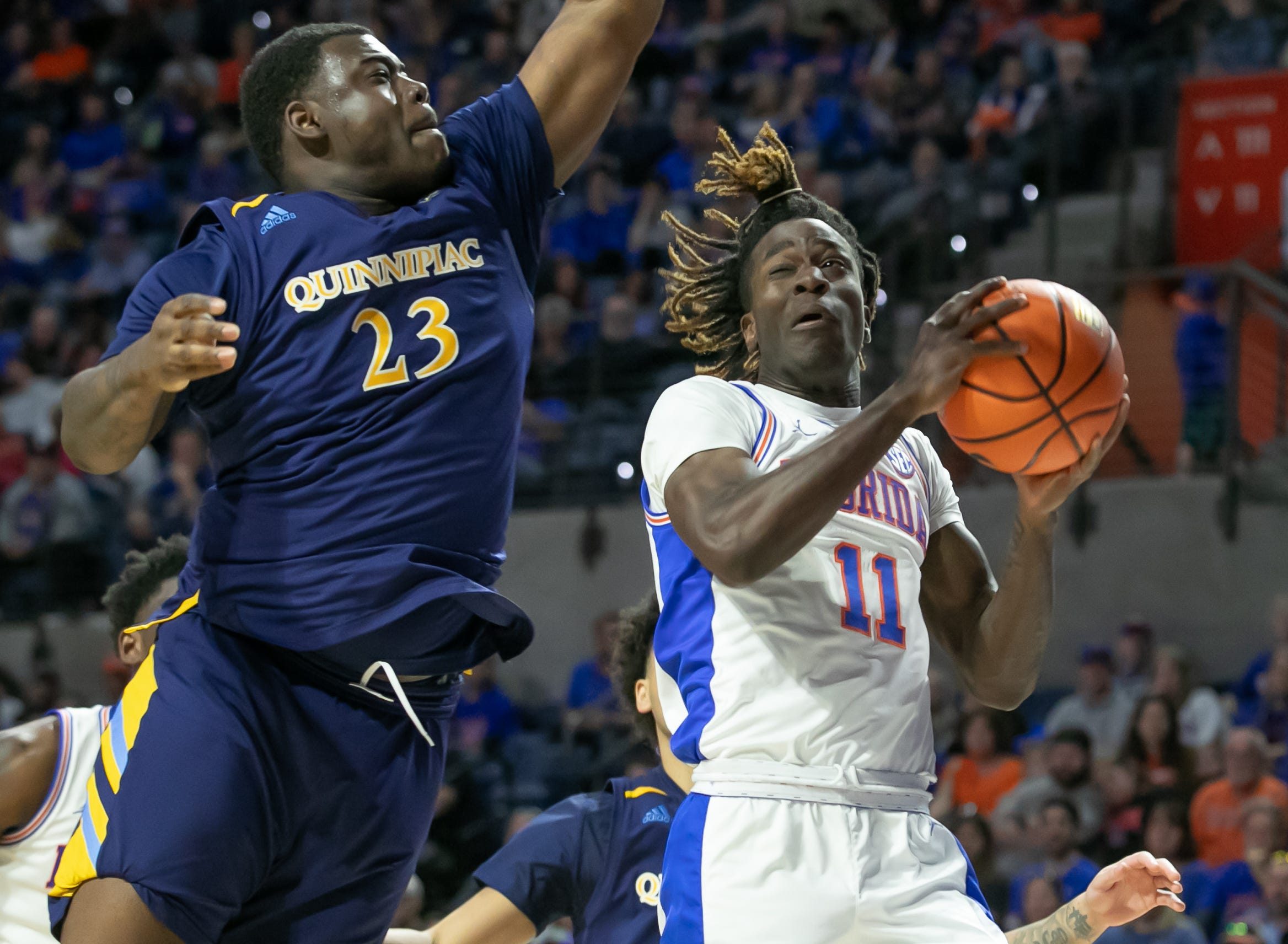 Florida Gators guard Denzel Aberdeen (11) drives for the basket as Quinnipiac Bobcats forward JJ Riggins (23) blocks during second half action as Quinnipiac takes on Florida during a NCAA mens basketball game at Exactech Arena at the Stephen C. O'Connell Center in Gainesville, FL on Saturday, December 30, 2023. Florida won handily 97-72. [Alan Youngblood/Gainesville Sun]