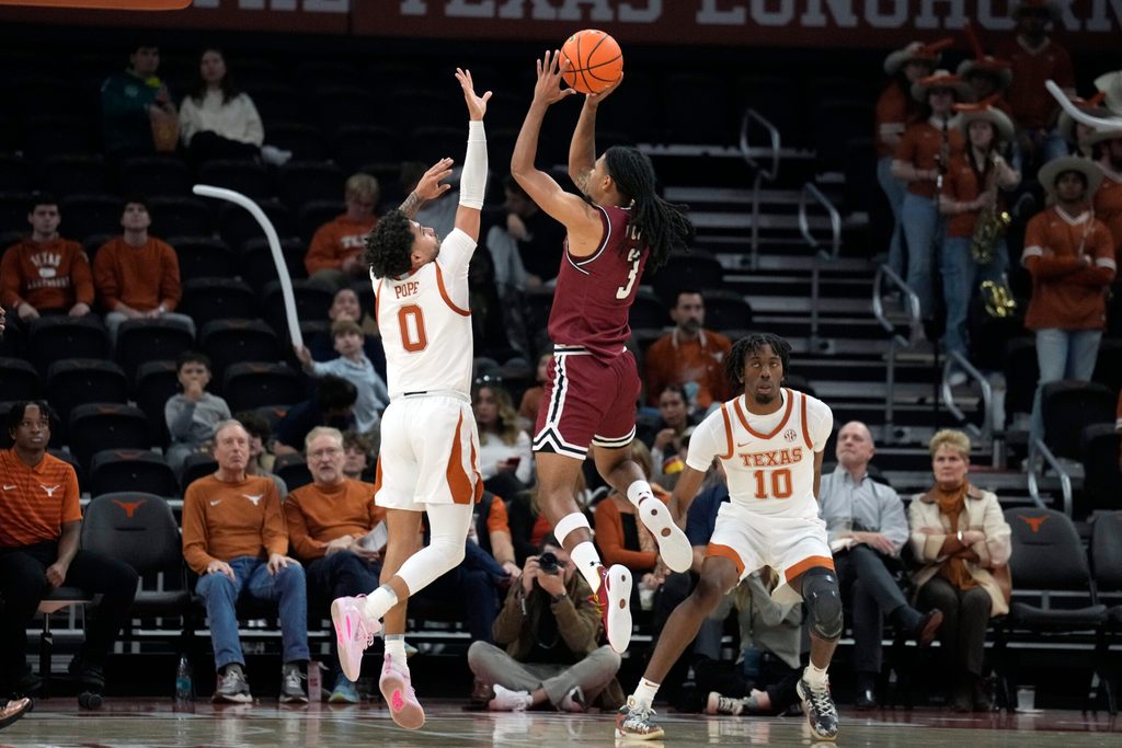 Dec 12, 2024; Austin, Texas, USA; New Mexico State Aggies guard Christian Cook (3) shoots over guard Jordan Pope (0) during the second half at Moody Center. Mandatory Credit: Scott Wachter-Imagn Images