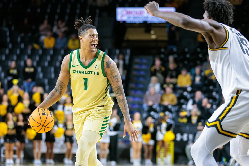 Jan 14, 2025; Wichita, Kansas, USA; Charlotte 49ers forward Giancarlo Rosado (1) brings the ball up court during the first half against the Wichita State Shockers at Charles Koch Arena. Mandatory Credit: William Purnell-Imagn Images