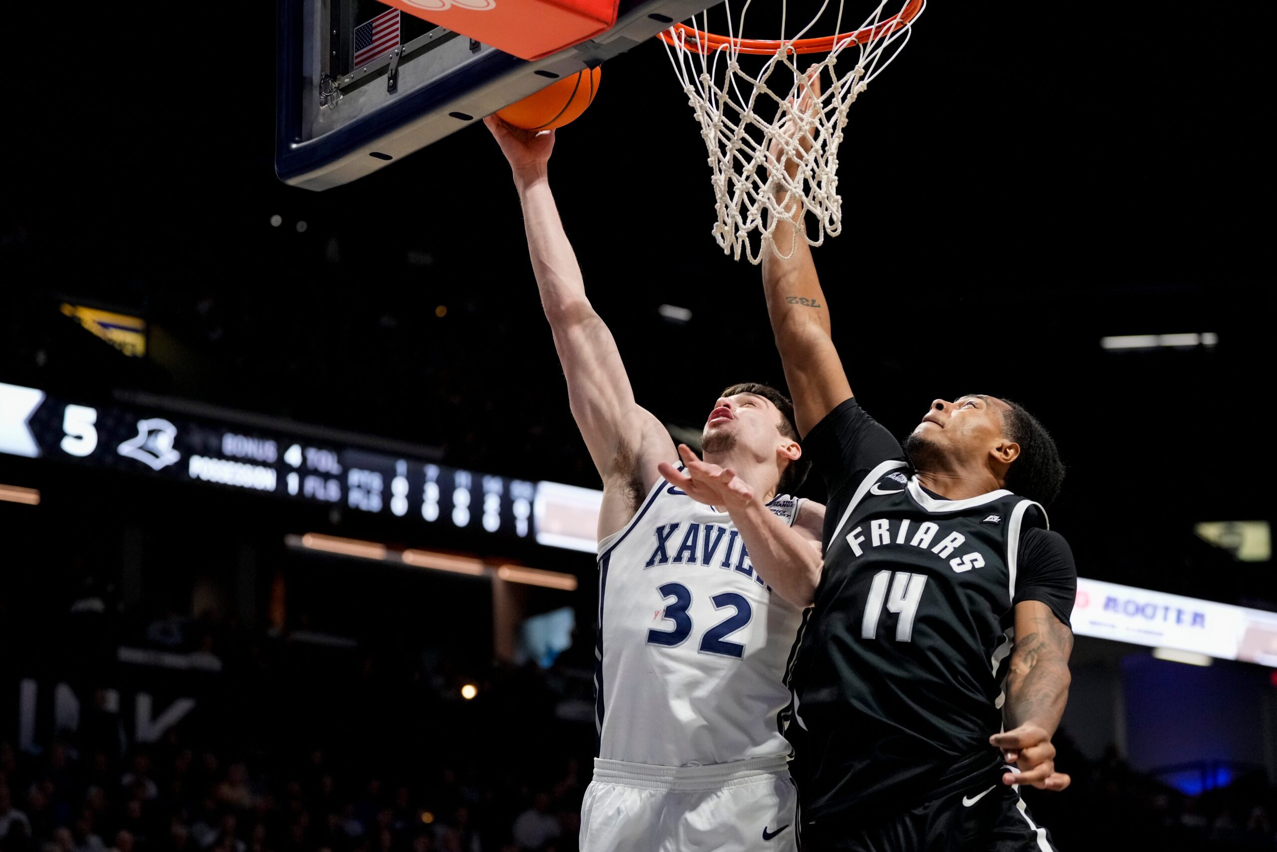 Xavier Musketeers forward Zach Freemantle (32) lays up against Providence Friars guard Corey Floyd Jr. (14) in the first half of the NCAA Big East men’s basketball game between the Xavier Musketeers and the Providence Friars at the Cintas Center in Cincinnati on Saturday, March 8, 2025.