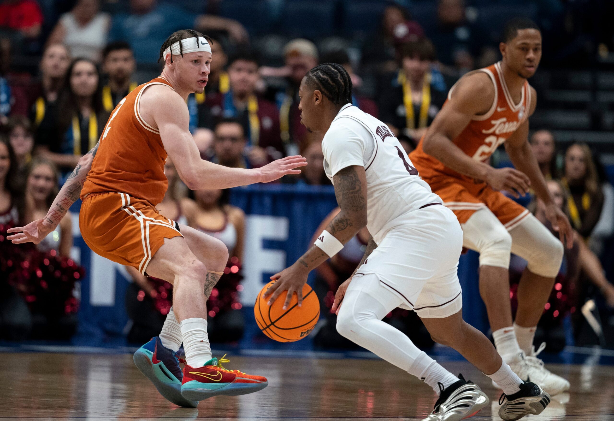 Texas A&M Aggies guard Wade Taylor IV (4) drives around Texas Longhorns guard Chendall Weaver (2) during their second round game of the SEC Men's Basketball Tournament at Bridgestone Arena in Nashville, Tenn., Thursday, March 13, 2025.