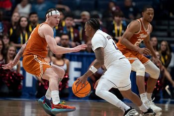 Texas A&M Aggies guard Wade Taylor IV (4) drives around Texas Longhorns guard Chendall Weaver (2) during their second round game of the SEC Men's Basketball Tournament at Bridgestone Arena in Nashville, Tenn., Thursday, March 13, 2025.