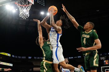 Mar 16, 2025; Fort Worth, TX, USA; Memphis Tigers guard PJ Haggerty (4) scores a basket over UAB Blazers guard Efrem Johnson (8) during the second half at Dickies Arena. Mandatory Credit: Chris Jones-Imagn Images