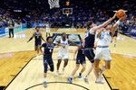 Mar 20, 2025; Lexington, KY, USA;  Utah State Aggies center Isaac Johnson (20) blocks the shot of UCLA Bruins guard Kobe Johnson (0) during the second half in the first round of the NCAA Tournament at Rupp Arena. Mandatory Credit: Jordan Prather-Imagn Images