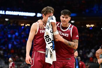 Mar 21, 2025; Milwaukee, WI, USA; Troy Trojans forward Thomas Dowd (1) holds their face in a towel as forward Victor Valdes (11) hugs them following a loss to the Kentucky Wildcats at Fiserv Forum. Mandatory Credit: Benny Sieu-Imagn Images