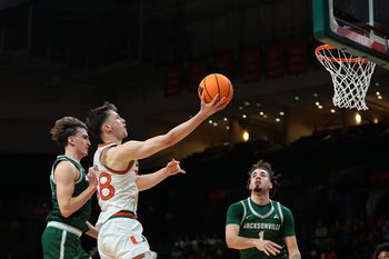 Nov 3, 2025; Coral Gables, Florida, USA; Miami Hurricanes forward Timotej Malovec (88) drives to the basket against Jacksonville Dolphins guard Hayden Wood (8) during the first half at Watsco Center. Mandatory Credit: Sam Navarro-Imagn Images