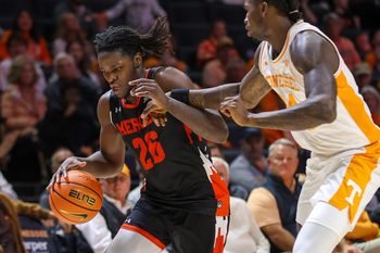 Nov 3, 2025; Knoxville, Tennessee, USA;  Mercer Bears center Armani Mighty (26) moves the ball against Tennessee Volunteers center Felix Okpara (34) during the second half at Thompson-Boling Arena at Food City Center. Mandatory Credit: Randy Sartin-Imagn Images
