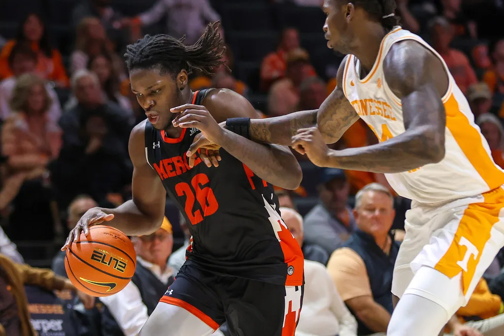 Nov 3, 2025; Knoxville, Tennessee, USA; Mercer Bears center Armani Mighty (26) moves the ball against Tennessee Volunteers center Felix Okpara (34) during the second half at Thompson-Boling Arena at Food City Center. Mandatory Credit: Randy Sartin-Imagn Images
