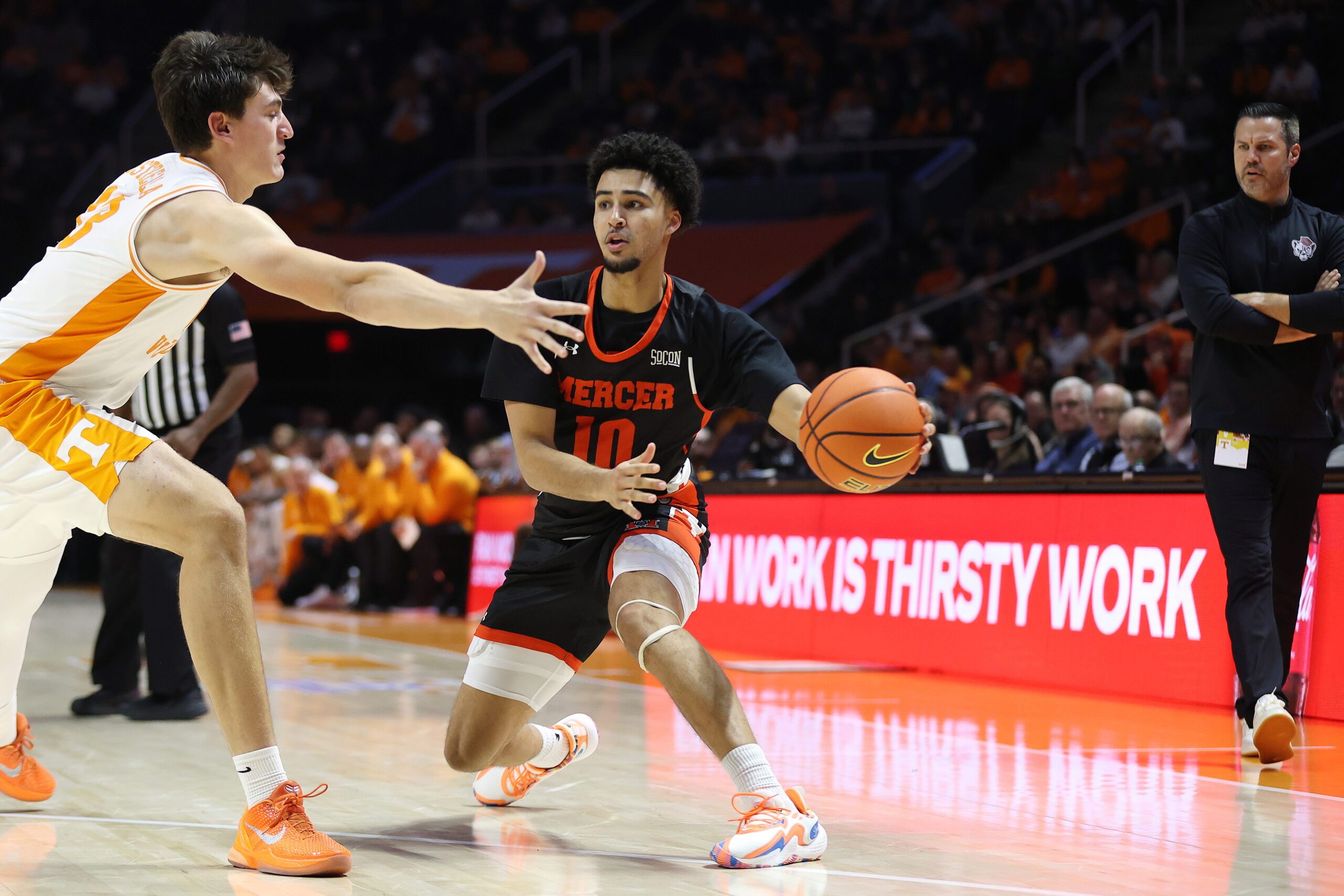 Nov 3, 2025; Knoxville, Tennessee, USA;  Mercer Bears guard Tristan Gross (10) moves the ball against Tennessee Volunteers forward J.P. Estrella (13) during the second half at Thompson-Boling Arena at Food City Center. Mandatory Credit: Randy Sartin-Imagn Images
