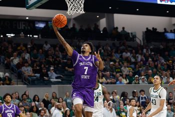Nov 14, 2025; Waco, Texas, USA; Tarleton State Texans guard Dior Johnson (7) attempts a layup ahead of Baylor Bears guard Tounde Yessoufou (24) during the first half at Paul and Alejandra Foster Pavilion. Mandatory Credit: Chris Jones-Imagn Images