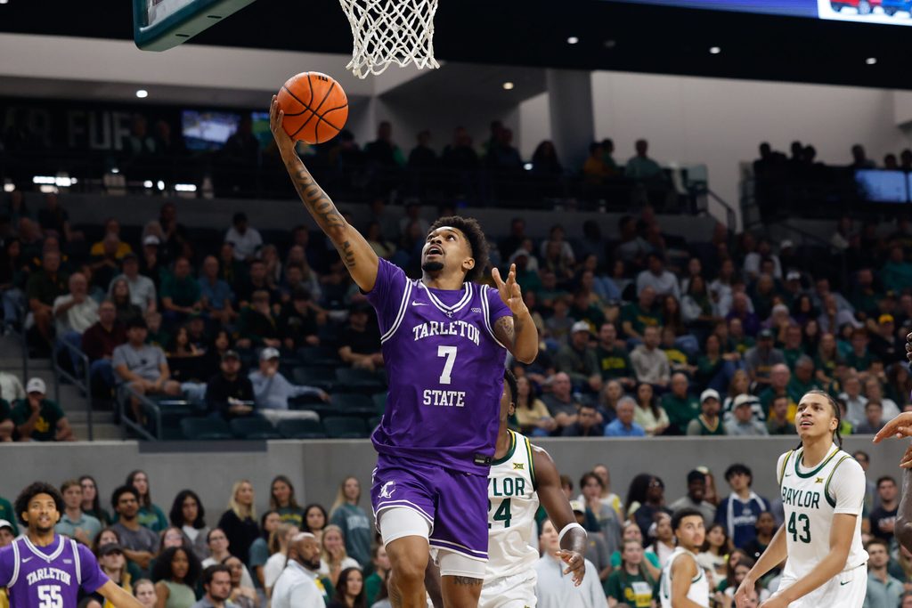 Nov 14, 2025; Waco, Texas, USA; Tarleton State Texans guard Dior Johnson (7) attempts a layup ahead of Baylor Bears guard Tounde Yessoufou (24) during the first half at Paul and Alejandra Foster Pavilion. Mandatory Credit: Chris Jones-Imagn Images
