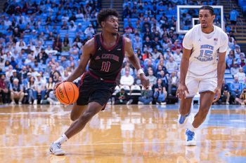 Nov 14, 2025; Chapel Hill, North Carolina, USA; North Carolina Central Eagles guard Gage Lattimore (11) drives past North Carolina Tar Heels forward Jarin Stevenson (15) during the first half at Dean E. Smith Center. Mandatory Credit: Scott Kinser-Imagn Images