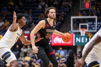 Nov 17, 2025; Morgantown, West Virginia, USA; Lafayette Leopards forward Luke Bevilacqua (34) dribbles against West Virginia Mountaineers forward DJ Thomas (5) during the first half at WVU Coliseum. Mandatory Credit: Ben Queen-Imagn Images