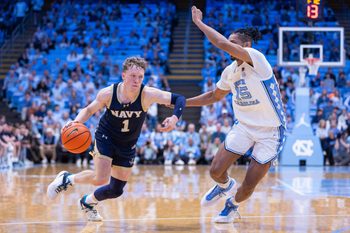 Nov 18, 2025; Chapel Hill, North Carolina, USA; Navy Midshipmen guard Austin Benigni (1) drives on North Carolina Tar Heels forward Jarin Stevenson (15) during the first half at Dean E. Smith Center. Mandatory Credit: Scott Kinser-Imagn Images