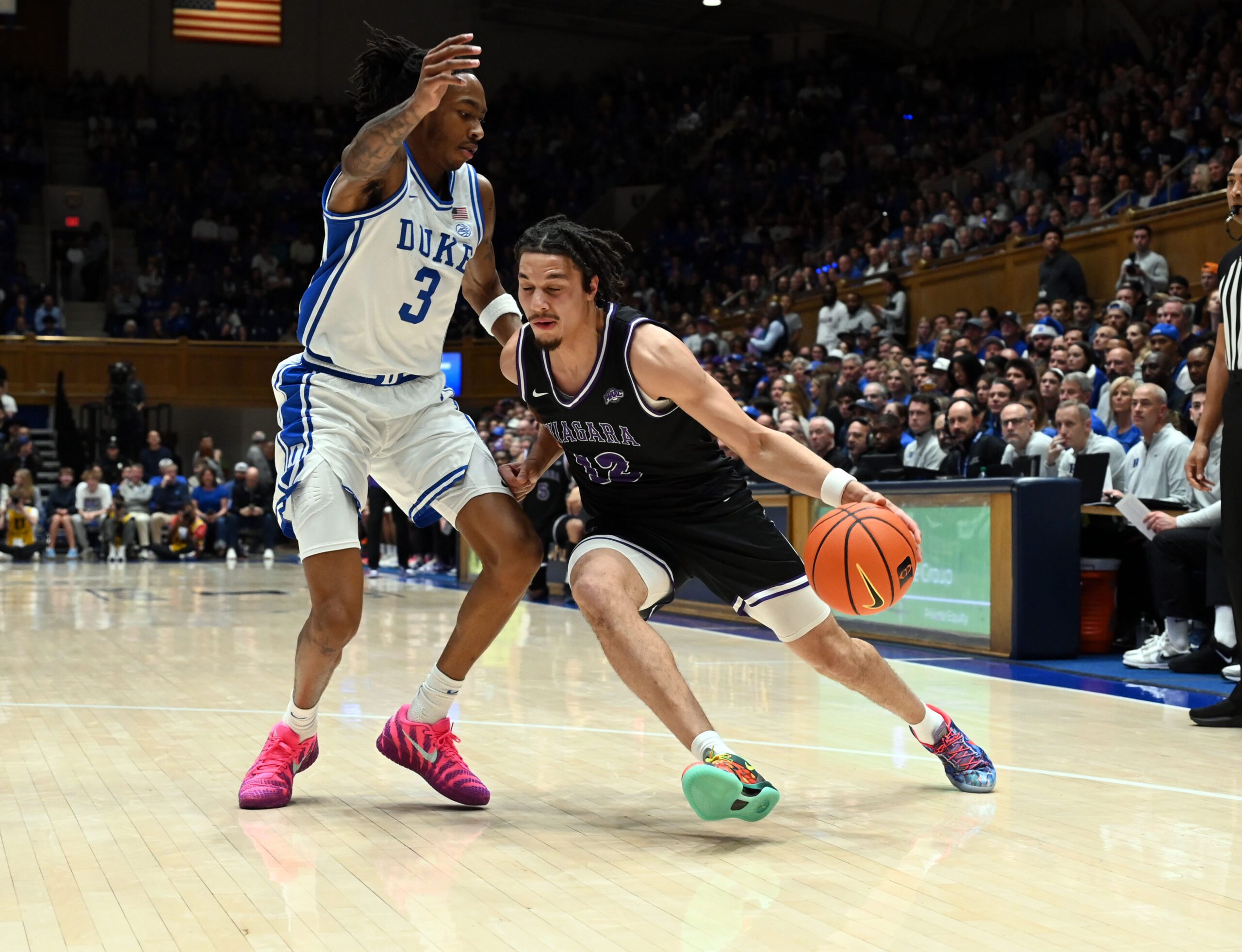 Nov 21, 2025; Durham, North Carolina, USA; Niagara Purple Eagles forward Drew Larson (22) drives to the basket as Duke Blue Devils forward Isaiah Evans (3) defends during the first half at Cameron Indoor Stadium. Mandatory Credit: Rob Kinnan-Imagn Images