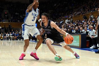Nov 21, 2025; Durham, North Carolina, USA; Niagara Purple Eagles forward Drew Larson (22) drives to the basket as Duke Blue Devils forward Isaiah Evans (3) defends during the first half at Cameron Indoor Stadium. Mandatory Credit: Rob Kinnan-Imagn Images
