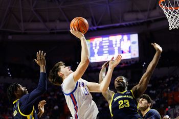 Nov 21, 2025; Gainesville, Florida, USA; Florida Gators forward Alex Condon (21) shoots over Merrimack Warriors guard Ernest Shelton (3) and Merrimack Warriors forward KC Ugwuakazi (23) during the second half at Exactech Arena at the Stephen C. O'Connell Center. Mandatory Credit: Matt Pendleton-Imagn Images