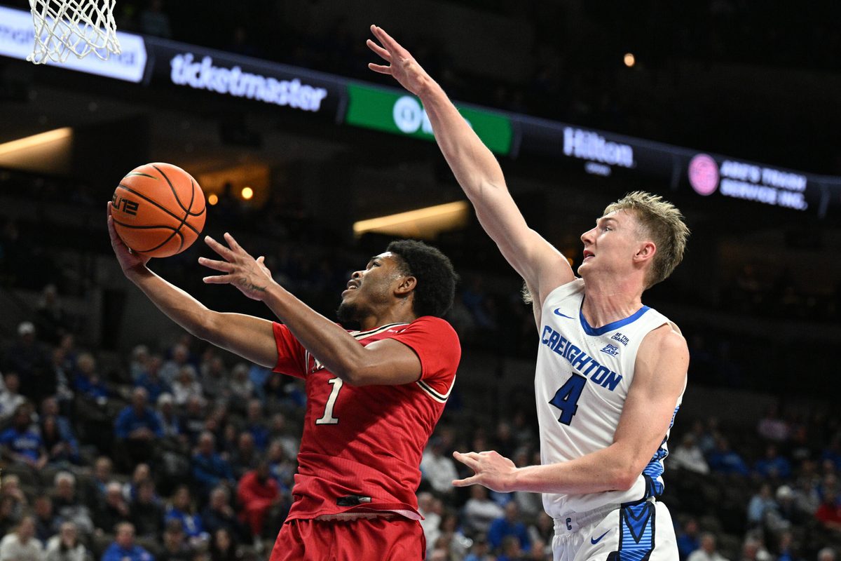 Dec 2, 2025; Omaha, Nebraska, USA; Nicholls State Colonels guard Trae English (1) scores against Creighton Bluejays guard Josh Dix (4) during the first half at CHI Health Center Omaha. Mandatory Credit: Steven Branscombe-Imagn Images