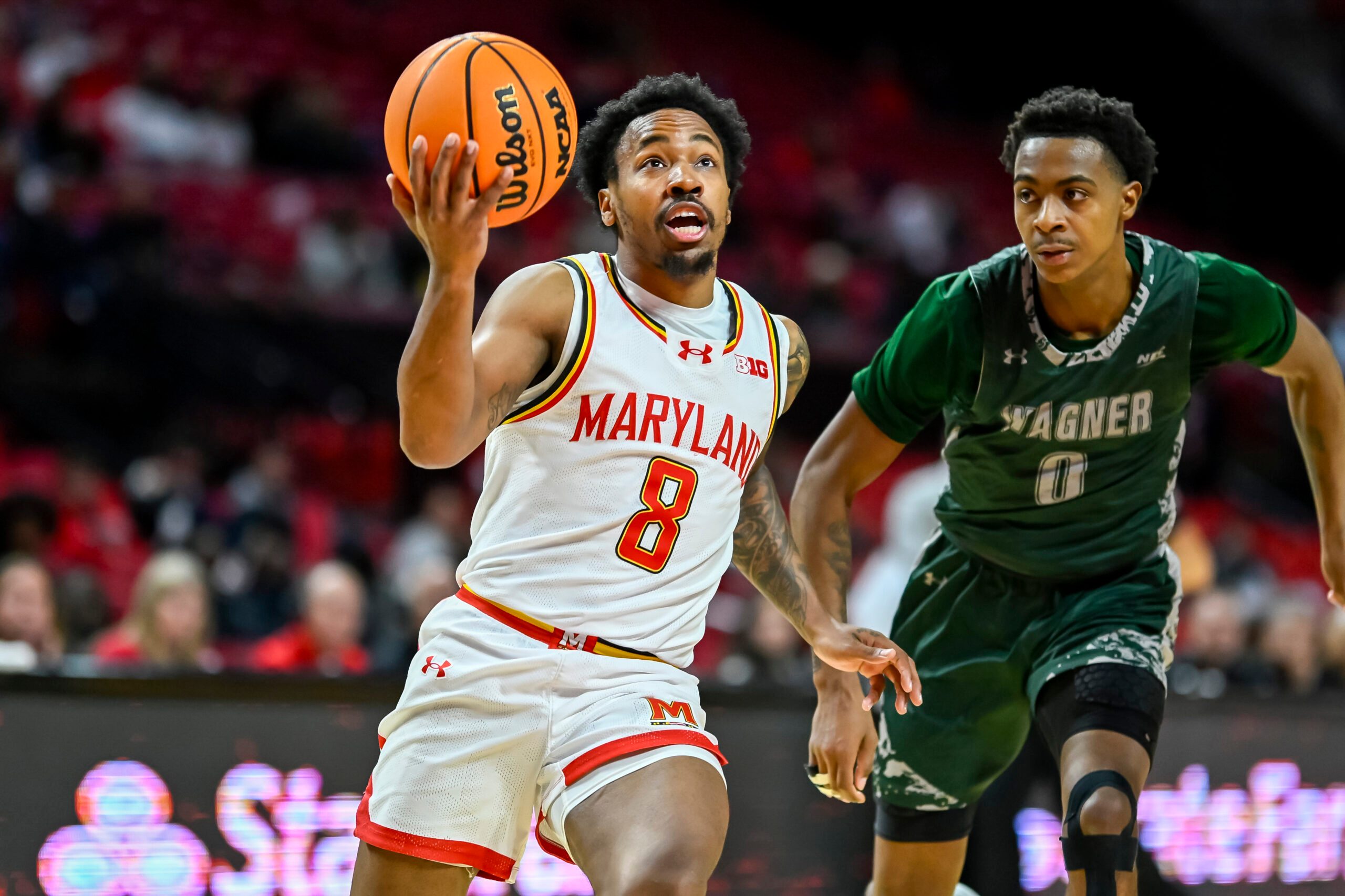 Dec 2, 2025; College Park, Maryland, USA;  Maryland Terrapins guard David Coit (8) makes a move to the basket on Wagner Seahawks guard Nick Jones (0) during the second half at Xfinity Center. Mandatory Credit: Tommy Gilligan-Imagn Images