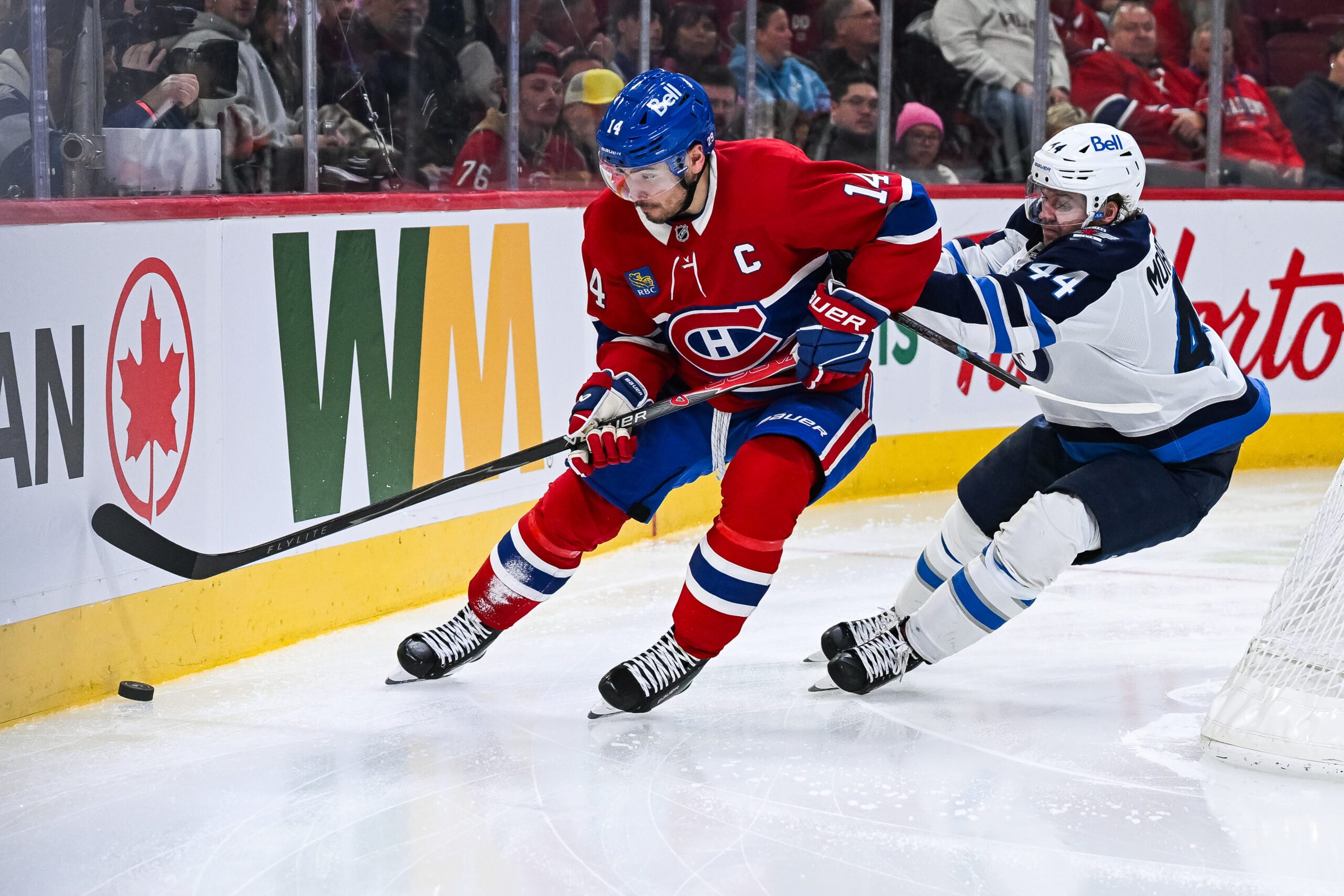 Dec 3, 2025; Montreal, Quebec, CAN; Montreal Canadiens center Nick Suzuki (14) plays the puck against Winnipeg Jets defenseman Josh Morrissey (44) during the third period at Bell Centre. Mandatory Credit: David Kirouac-Imagn Images