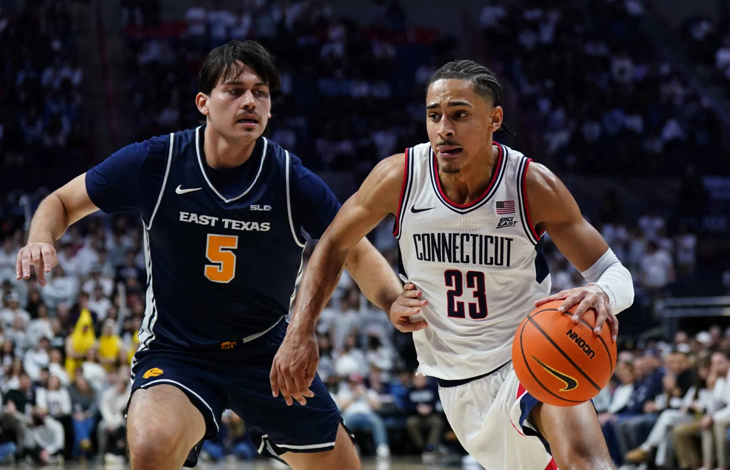 Dec 5, 2025; Storrs, Connecticut, USA; UConn Huskies forward Jayden Ross (23) drives the ball against East Texas A&M Lions forward Tay Mosher (5) in the second half at Harry A. Gampel Pavilion. Mandatory Credit: David Butler II-Imagn Images