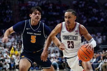 Dec 5, 2025; Storrs, Connecticut, USA; UConn Huskies forward Jayden Ross (23) drives the ball against East Texas A&M Lions forward Tay Mosher (5) in the second half at Harry A. Gampel Pavilion. Mandatory Credit: David Butler II-Imagn Images