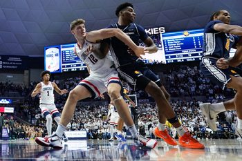 Dec 5, 2025; Storrs, Connecticut, USA; UConn Huskies center Eric Reibe (12) defends against East Texas A&M Lions forward Ronnie Harrison (0) in the second half at Harry A. Gampel Pavilion. Mandatory Credit: David Butler II-Imagn Images