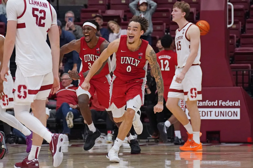 Dec 7, 2025; Stanford, California, USA; UNLV Runnin' Rebels guard Dra Gibbs-Lawhorn (0) and center Emmanuel Stephen (34) celebrates after the buzzer sounds as Stanford Cardinal forward/center Aidan Cammann (52) and Stanford Cardinal forward/center Oskar Giltay (15) look on in the second half at Maples Pavilion. Mandatory Credit: David Gonzales-Imagn Images